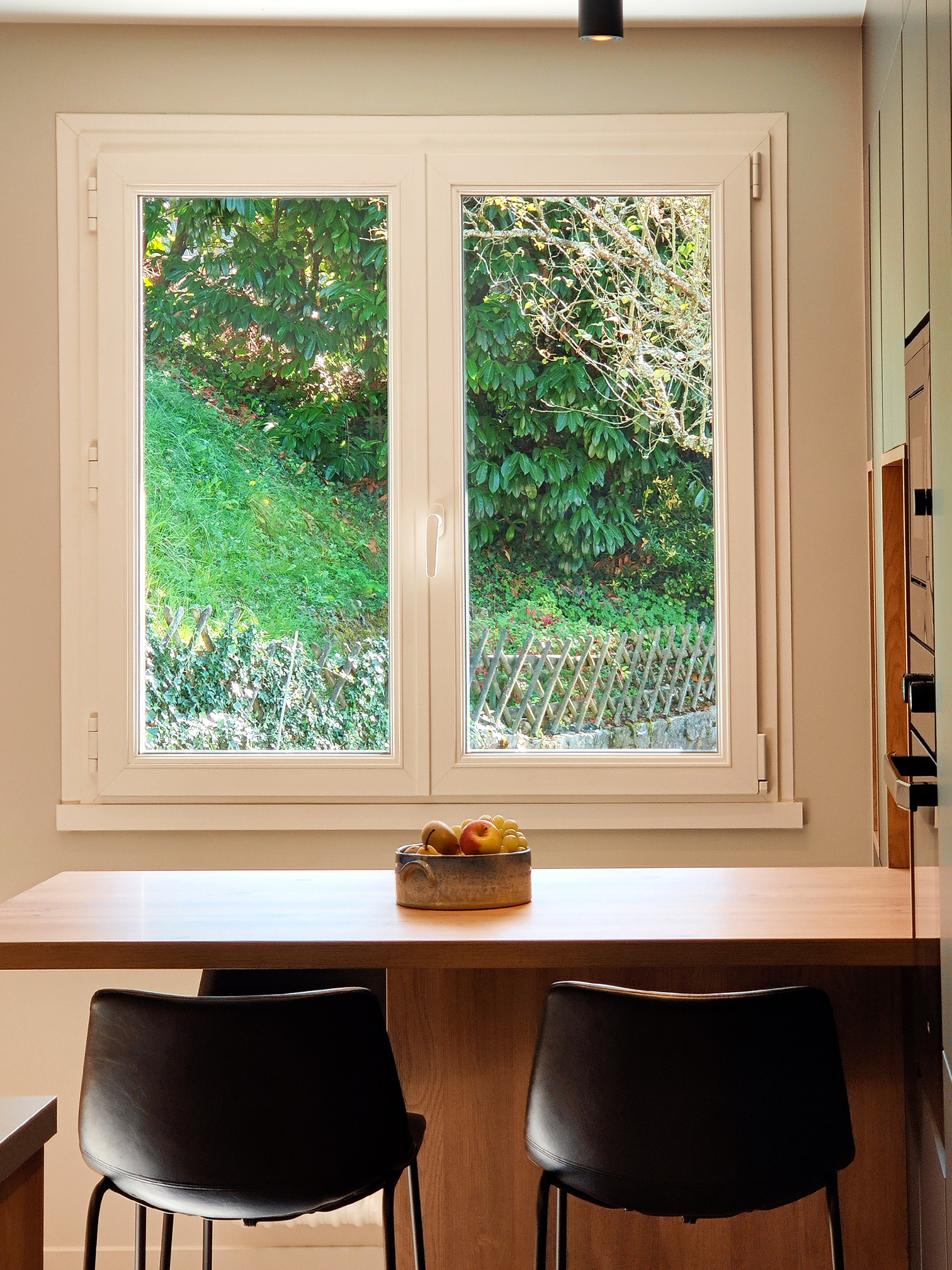 ilot en bois de chêne dans une cuisine contemporaine avec vue sur la nature