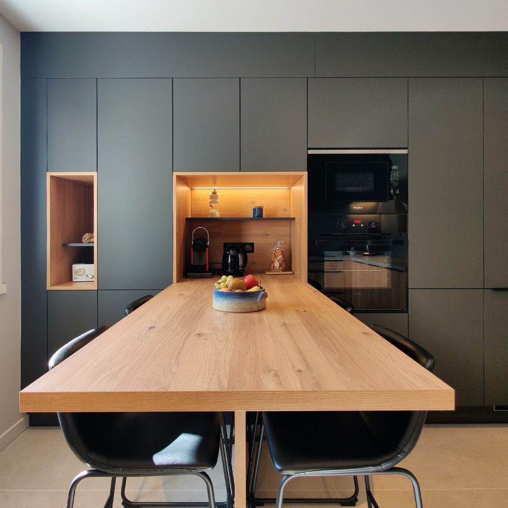 Mur technique cuisine contemporaine anthracite et bois de chêne avec niche rétro éclairée et portes invisibles